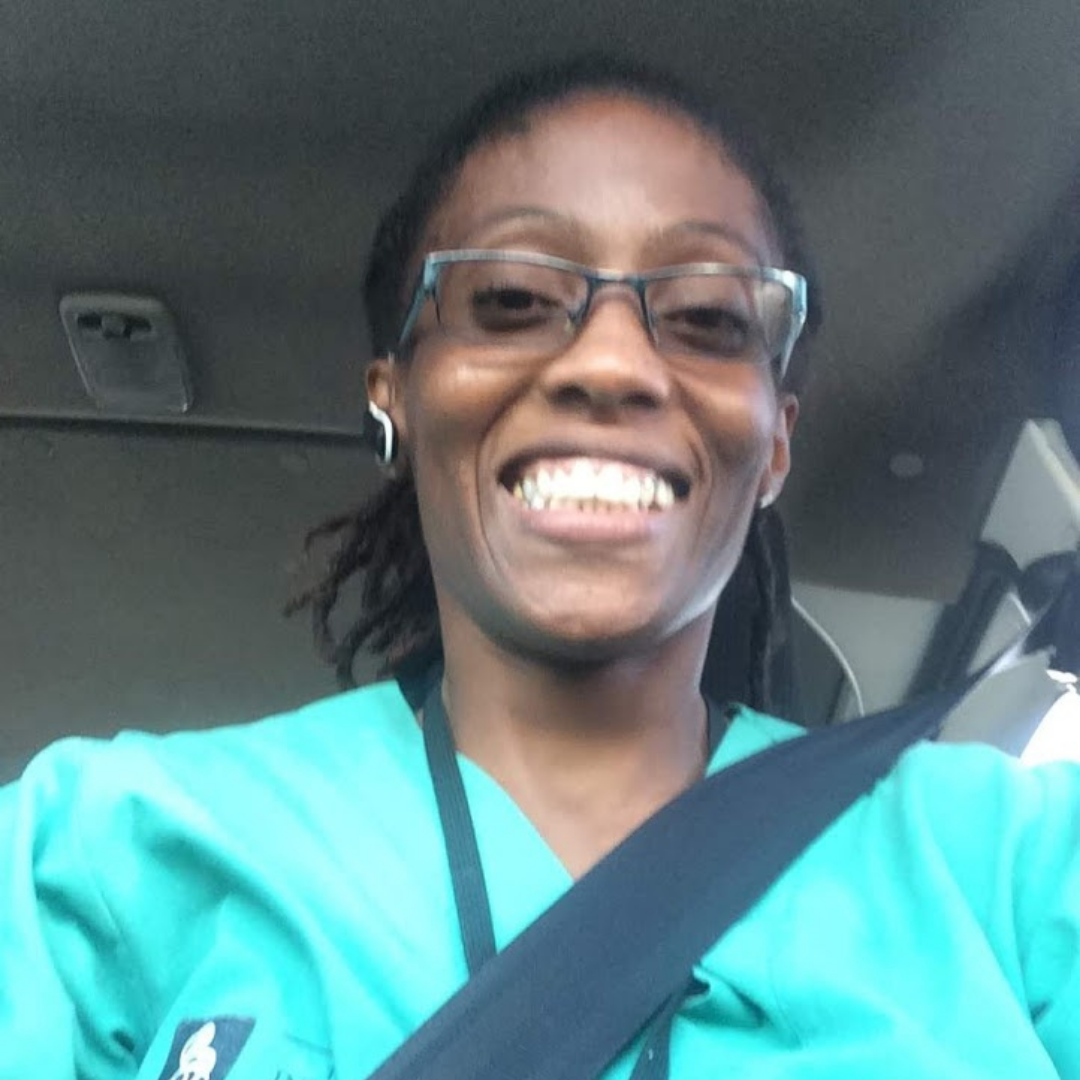 Smiling black woman with glasses sitting in car